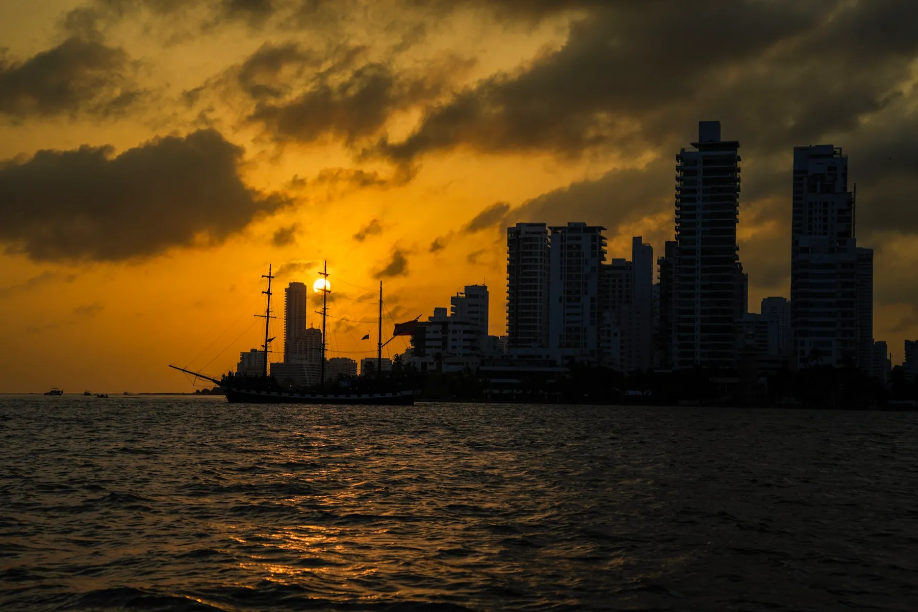 Sunset over Cartagena Bay with a galleon in front of the skyline